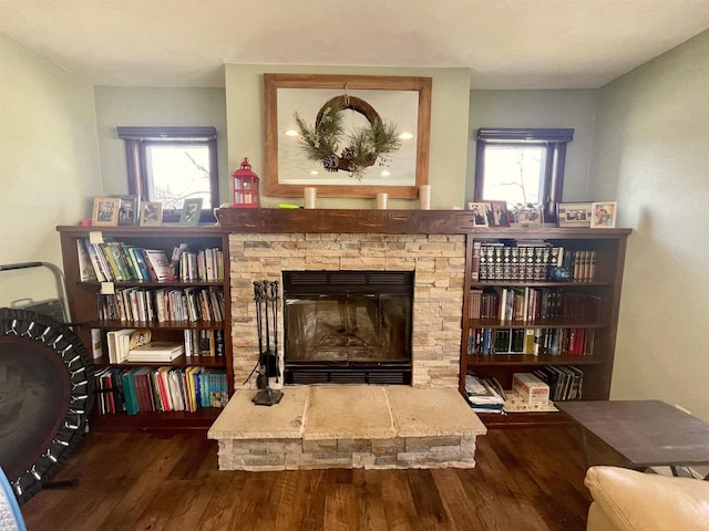 living area featuring a healthy amount of sunlight, dark hardwood / wood-style floors, and a fireplace