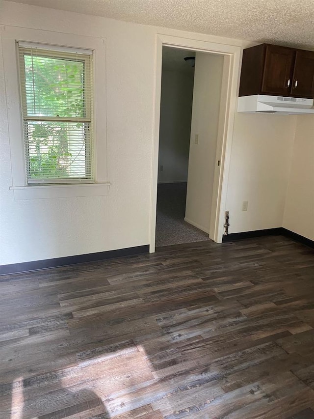 empty room featuring dark hardwood / wood-style flooring and a textured ceiling