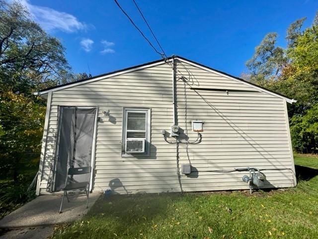 view of side of property featuring cooling unit and a yard