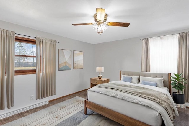 bedroom featuring ceiling fan, light colored carpet, and baseboard heating