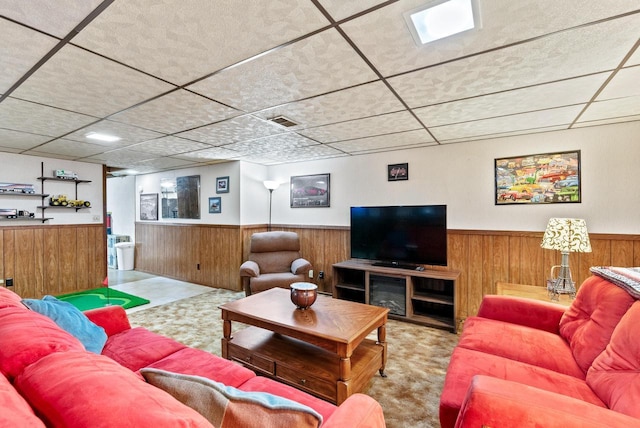 living room featuring a paneled ceiling and wooden walls