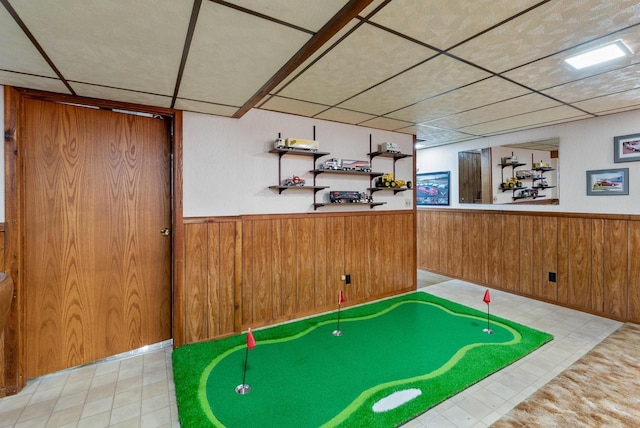 playroom with a paneled ceiling and wooden walls