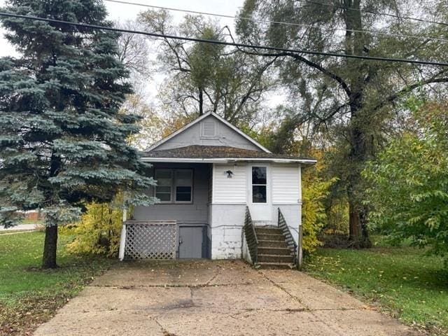 bungalow-style home featuring a front lawn