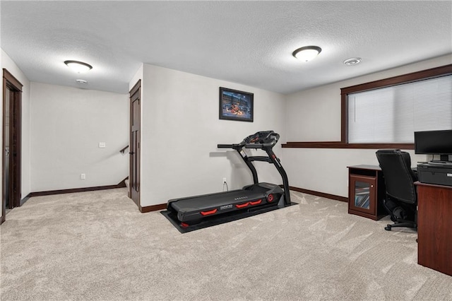 carpeted office featuring a textured ceiling