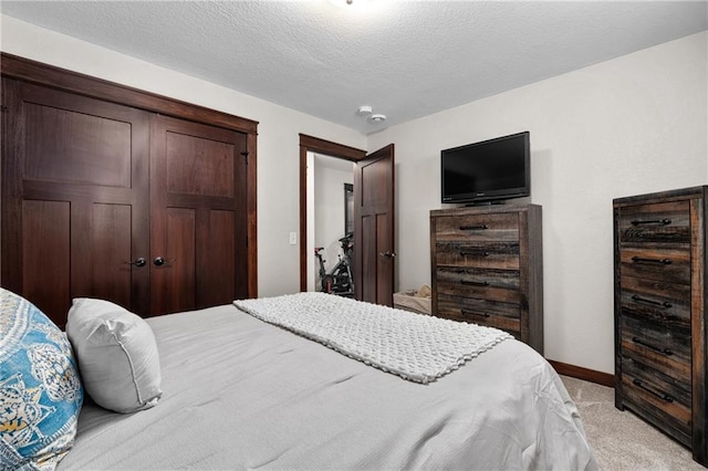 carpeted bedroom featuring a textured ceiling and a closet