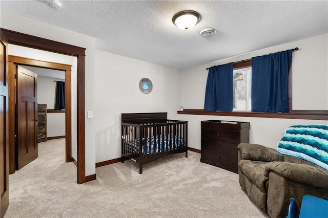 bedroom with light carpet and a textured ceiling