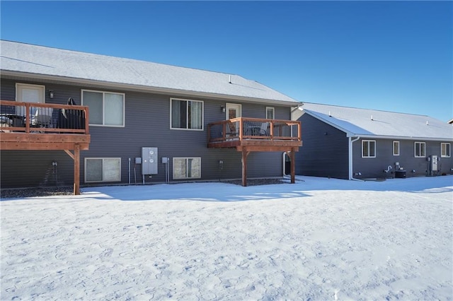 snow covered house featuring a deck