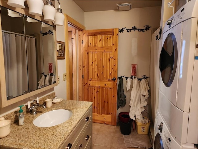 bathroom featuring stacked washer and dryer, vanity, and tile patterned floors