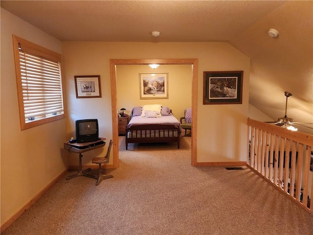 bedroom featuring light carpet, lofted ceiling, and a textured ceiling