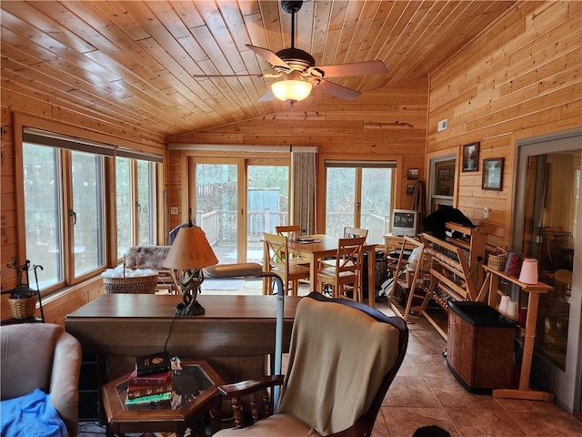 tiled dining area featuring lofted ceiling, a healthy amount of sunlight, wood ceiling, and wooden walls