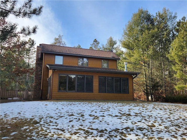 view of snow covered rear of property