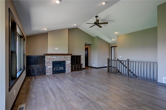 unfurnished living room featuring ceiling fan, wood-type flooring, a stone fireplace, and high vaulted ceiling