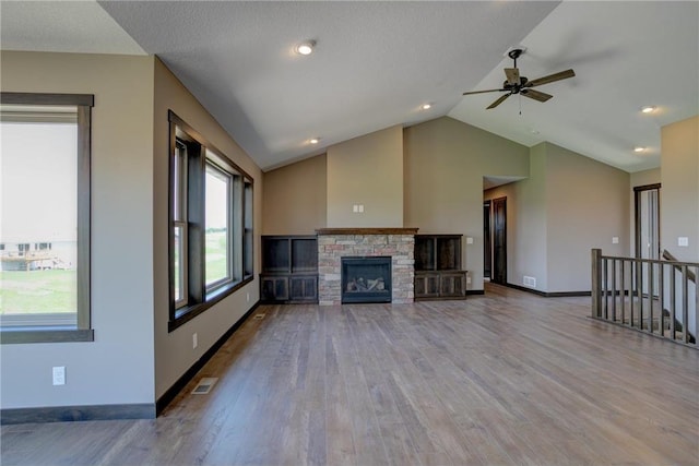 unfurnished living room with wood-type flooring, vaulted ceiling, and a fireplace