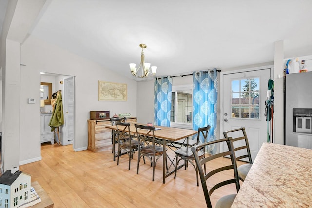 dining space featuring vaulted ceiling, a chandelier, and light wood-type flooring