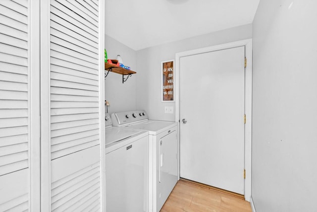 laundry area featuring separate washer and dryer and light wood-type flooring