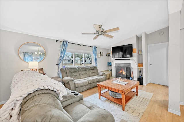 living room with ceiling fan, vaulted ceiling, and light hardwood / wood-style flooring