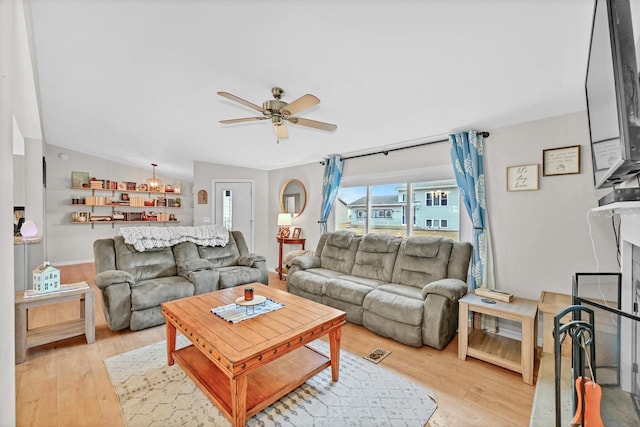 living room featuring ceiling fan, vaulted ceiling, and light hardwood / wood-style floors