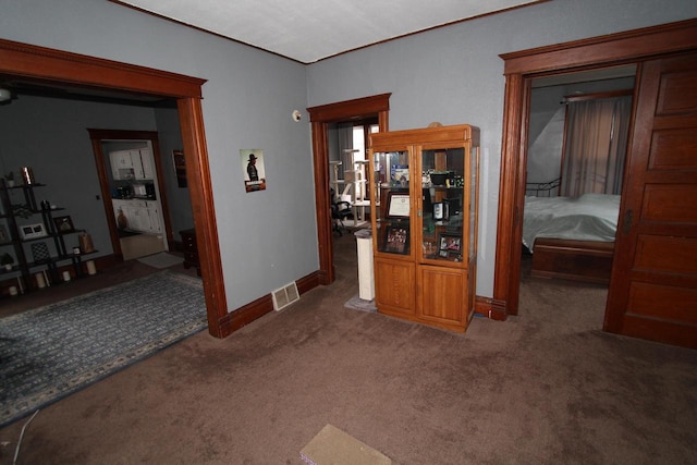 corridor featuring dark colored carpet