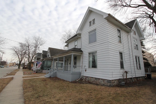 view of home's exterior with a lawn and covered porch