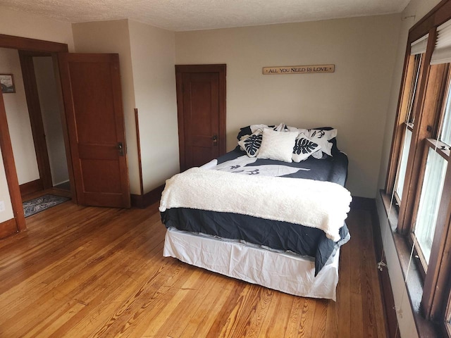 bedroom featuring wood-type flooring and a textured ceiling