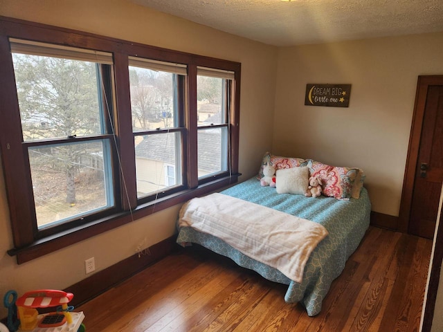 bedroom featuring dark hardwood / wood-style flooring and a textured ceiling