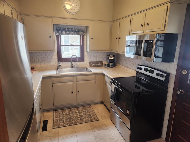 kitchen featuring stainless steel appliances, light tile patterned flooring, sink, and backsplash