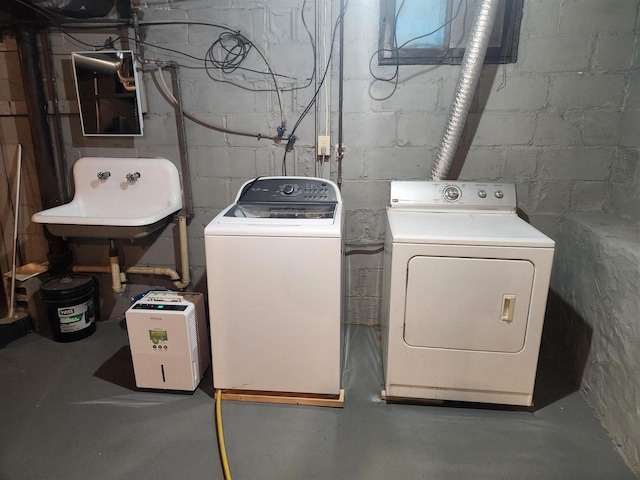 laundry area with separate washer and dryer and sink