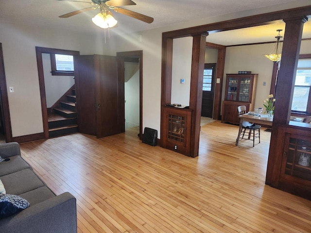 living room with ceiling fan, decorative columns, and light wood-type flooring