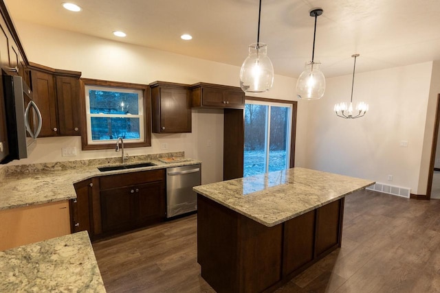 kitchen with hanging light fixtures, appliances with stainless steel finishes, sink, and dark brown cabinets