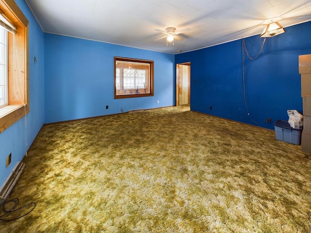 spare room featuring carpet floors, ceiling fan, and baseboard heating