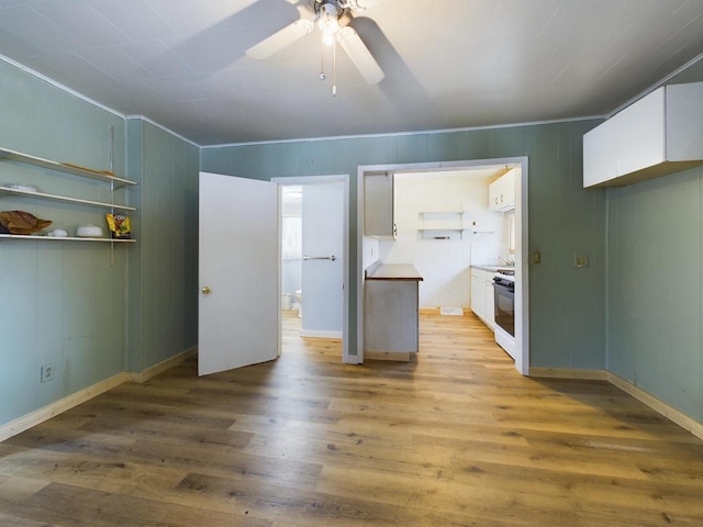 interior space featuring crown molding, light hardwood / wood-style floors, and ceiling fan