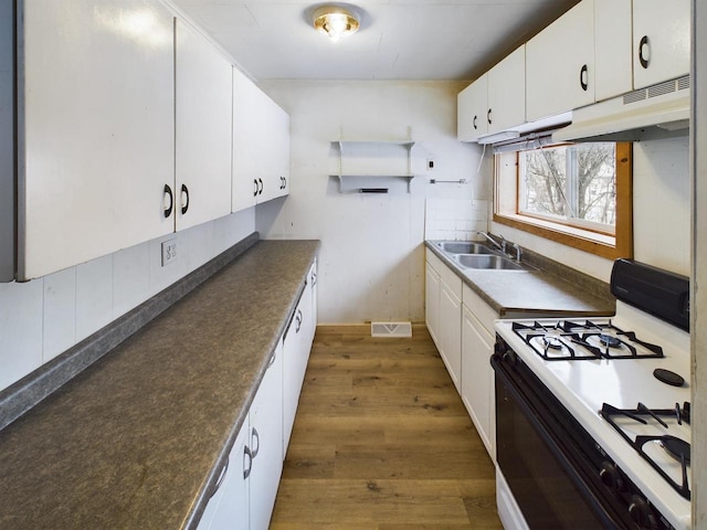 kitchen featuring sink, white cabinetry, tasteful backsplash, range with gas stovetop, and dark hardwood / wood-style flooring