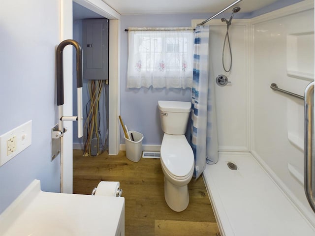 bathroom with wood-type flooring, electric panel, toilet, and a shower with shower curtain