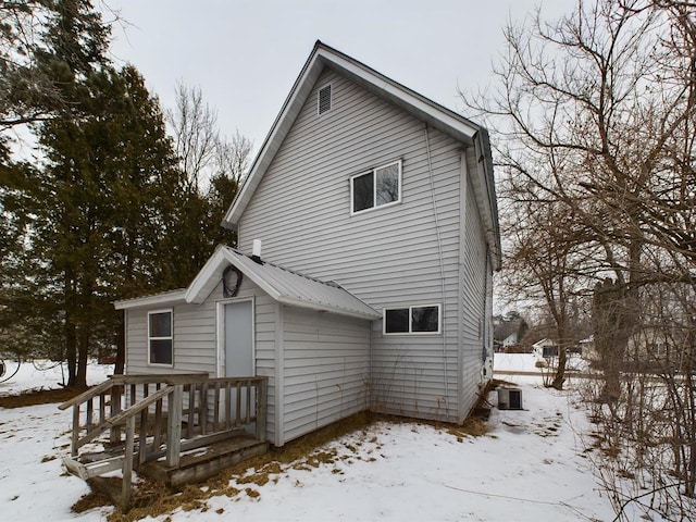 snow covered property featuring central AC