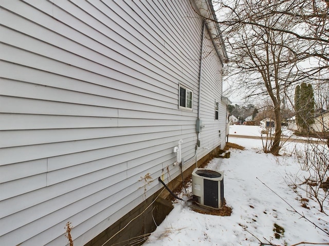 view of snow covered exterior with cooling unit