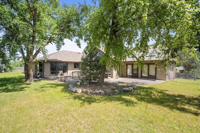 rear view of property featuring a yard and a patio area