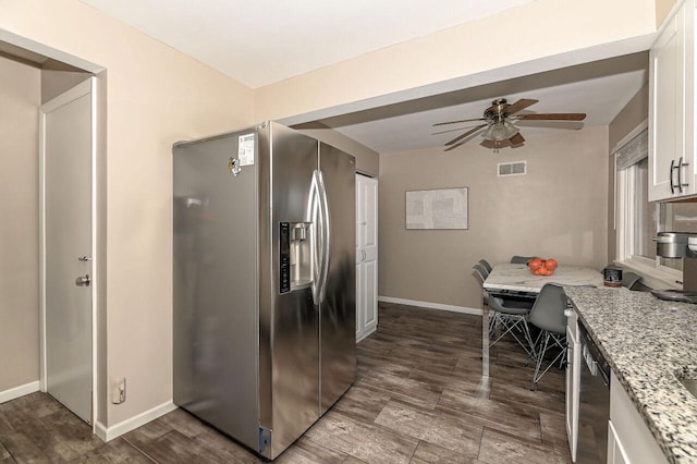 kitchen featuring white cabinetry, stainless steel fridge, ceiling fan, light stone countertops, and dark wood-type flooring