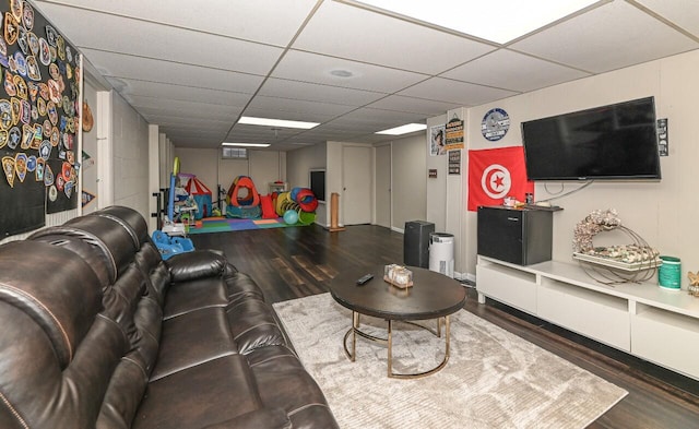 living room with dark hardwood / wood-style floors and a paneled ceiling