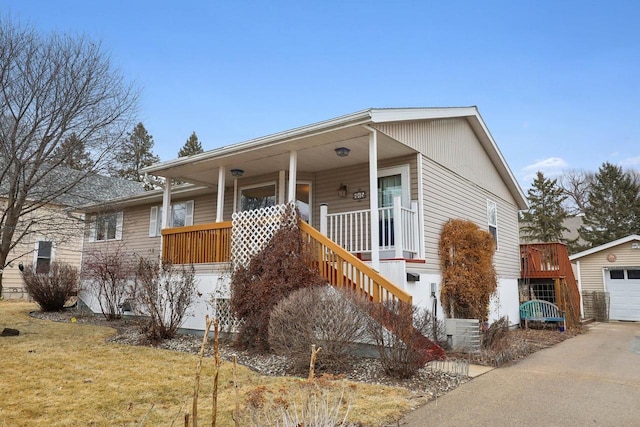 view of front of property featuring cooling unit, covered porch, a garage, an outdoor structure, and a front lawn