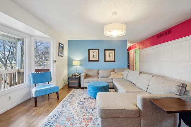 living room featuring a textured ceiling and light hardwood / wood-style floors