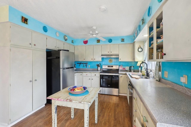 kitchen with dark wood-type flooring, sink, appliances with stainless steel finishes, ceiling fan, and decorative backsplash