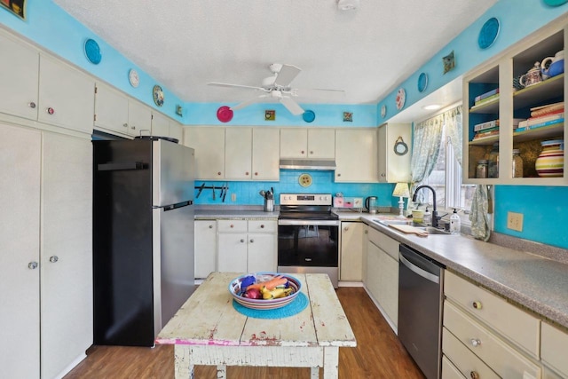 kitchen featuring stainless steel appliances, dark hardwood / wood-style floors, a center island, and sink