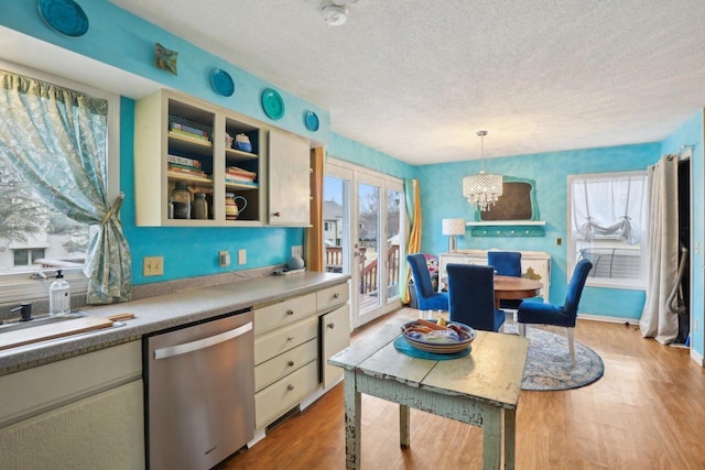 kitchen with pendant lighting, dishwasher, a notable chandelier, light hardwood / wood-style floors, and a textured ceiling