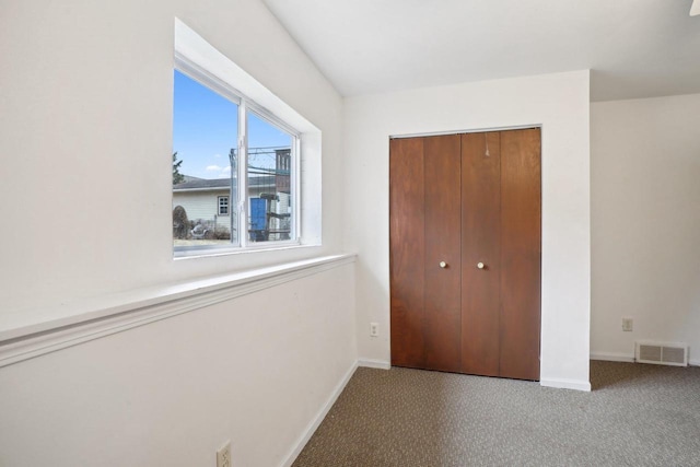 unfurnished bedroom featuring light carpet and a closet