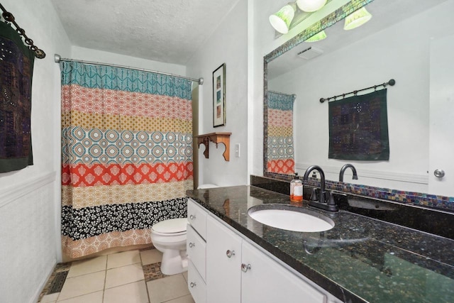 bathroom with tile patterned floors, toilet, a shower with curtain, a textured ceiling, and vanity