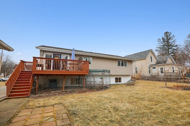 rear view of house with a deck and a lawn