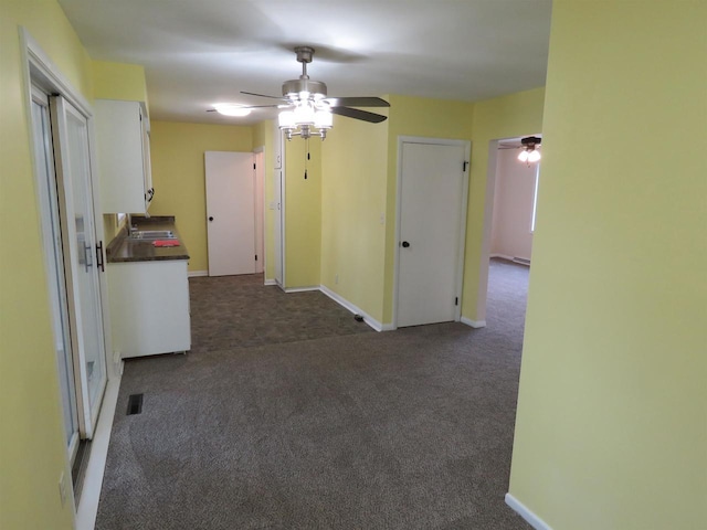 empty room featuring sink, dark carpet, and ceiling fan