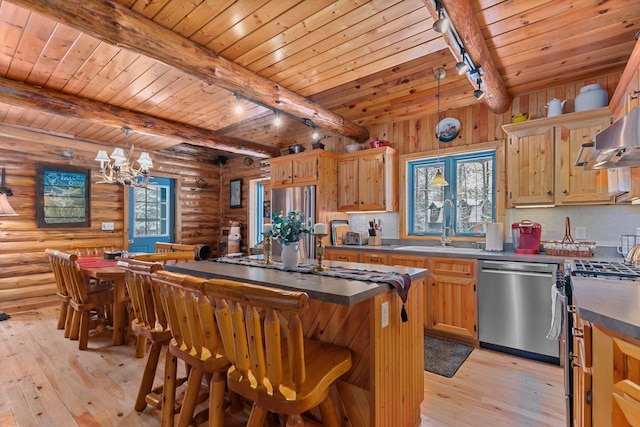 kitchen featuring rustic walls, hanging light fixtures, light hardwood / wood-style flooring, appliances with stainless steel finishes, and beamed ceiling