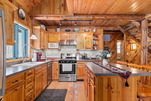 kitchen featuring pendant lighting, sink, a kitchen breakfast bar, stainless steel appliances, and light hardwood / wood-style flooring