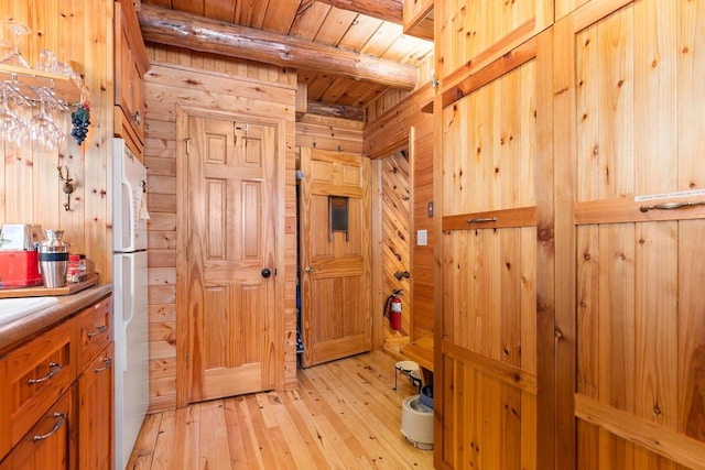 interior space featuring hardwood / wood-style floors, wooden walls, wooden ceiling, and beamed ceiling